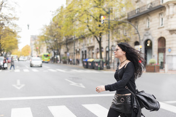 Fototapeta na wymiar Woman with sunglasses heavy metal style walking in the street.