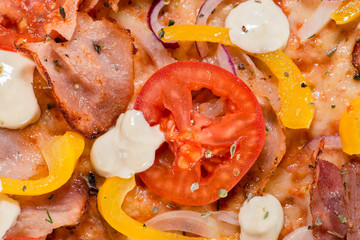 closeup Tasty pizza with tomatoes, cheese, basil and ham on a bl