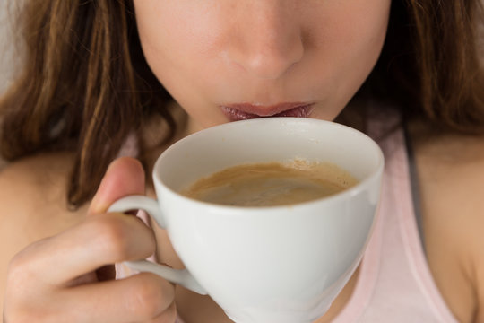 Woman drinking coffee close up