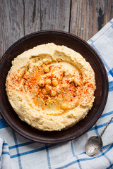 hummus of chickpeas, tahini paste and with paprika in a clay pla