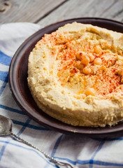 hummus of chickpeas, tahini paste and with paprika in a clay pla