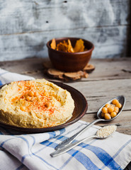 hummus of chickpeas, tahini paste and with paprika in a clay pla