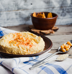 hummus of chickpeas, tahini paste and with paprika in a clay pla