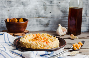 hummus of chickpeas, tahini paste and with paprika in a clay pla