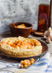 Appetizer hummus with tahini paste, olive oil, paprika in rustic
