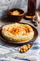 hummus of chickpeas, tahini paste and with paprika in a clay pla