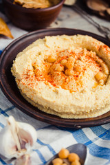 hummus of chickpeas, tahini paste and with paprika in a clay pla