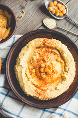 hummus of chickpeas, tahini paste and with paprika in a clay pla