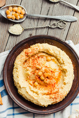 hummus of chickpeas, tahini paste and with paprika in a clay pla