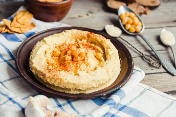 hummus of chickpeas, tahini paste and with paprika in a clay pla