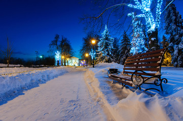 Red bench covered with snow  in winter park  
