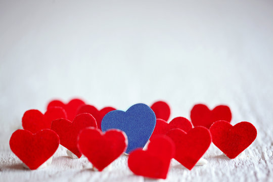 Blue heart and many red hearts on the white background. Valentin
