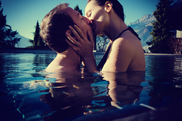Frau und Mann in Flitterwochen küssen im Pool