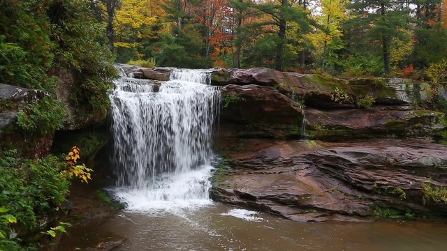 Whitewater tumbles over O Kun De Kun Falls, a beautiful remote waterfall in Michigan's western Upper Peninsula, in an autumn landscape.