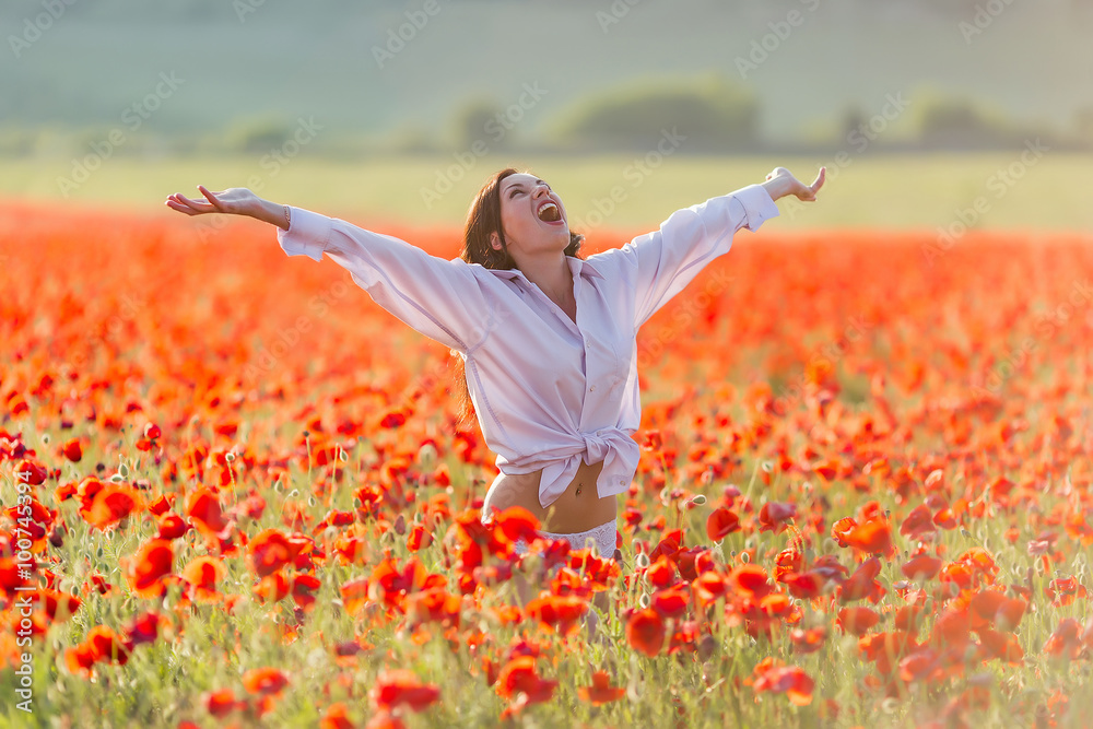 Wall mural Girl at blooming poppy field