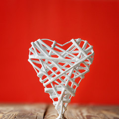 White heart handmade of rods on a red background. Valentine's Da