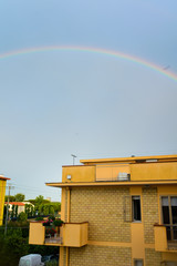 Rainbow at sunset under houses