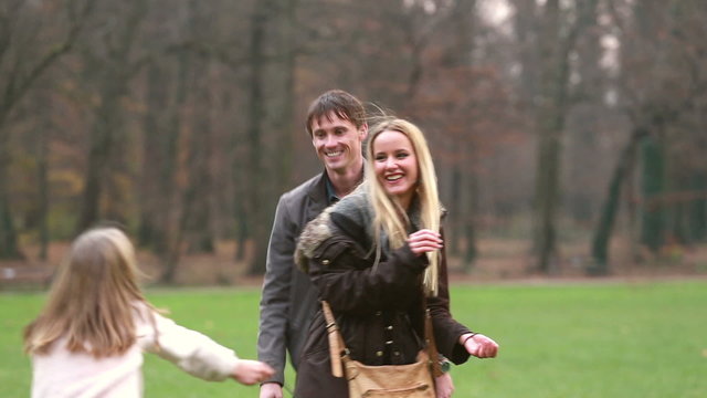 Parents playing with daughter in park