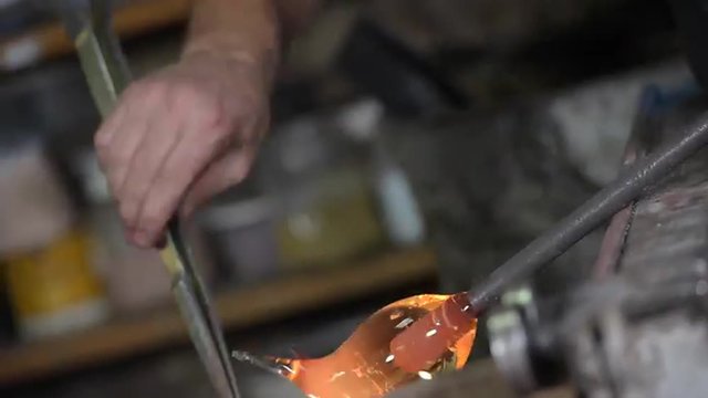 Glassblower forming molten glass