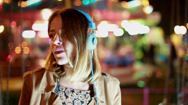 Portrait of girl shaking her head to the rhythm of music with headphones