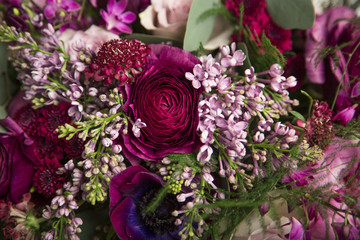 Beautiful close-up of a flower arrangement with purple and pink roses, peonies, anemones and lilac flowers