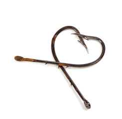 Old fish hooks in form of heart on white