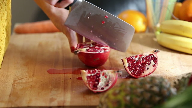 View of woman hands cutting pomegranate