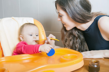 Obraz na płótnie Canvas Mom feeds the baby puree. Healthy and natural baby food.