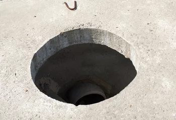 Papier Peint photo Canal Manhole without cover in new concrete block