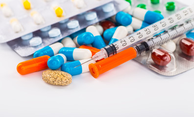 Various cold prescription bottles and a syringe isolated on a wh