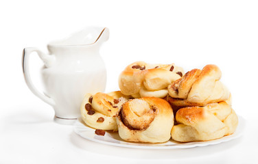 Obraz na płótnie Canvas House pastries: buns with raisin on a white plate near a white j