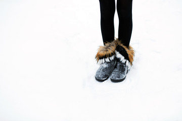 Ugg boots female legs in the snow in winter.