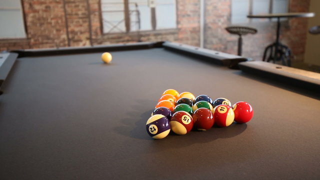 Pool Table Break to Start Game. Two shots. rise up on close up of billiard table and player is brushing the felt in preparation for the break then player starting game with break
