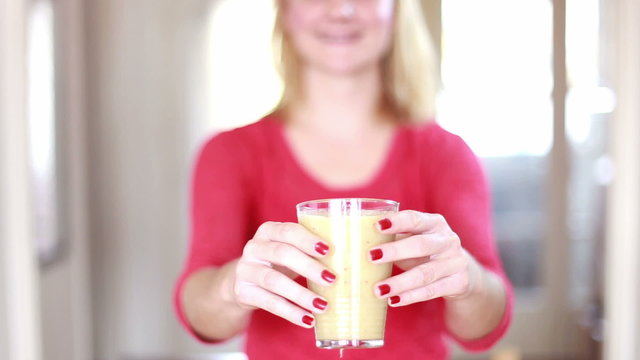 Woman's hands holding glass of fruit smoothie 