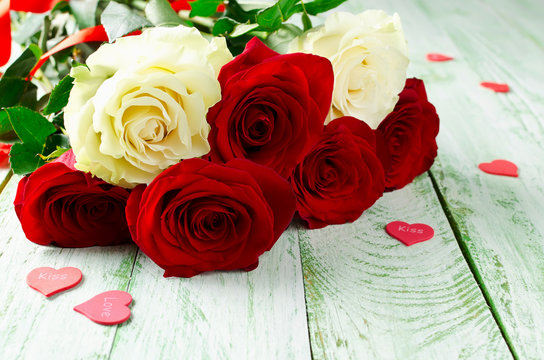 Red and white roses on wooden background