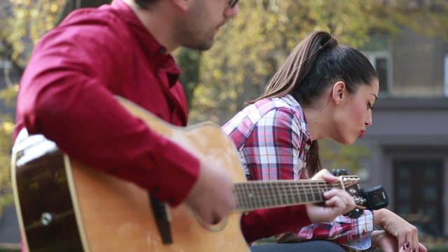 Beautiful woman singing while handsome man playing guitar