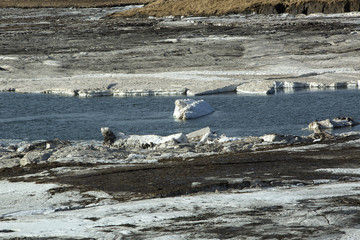 Glacial ice float away on a river bank, Iceland