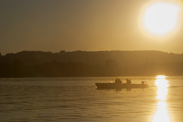 Motor boat, sunset at the lake