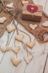 Heart shape cookies on wooden background with gift box