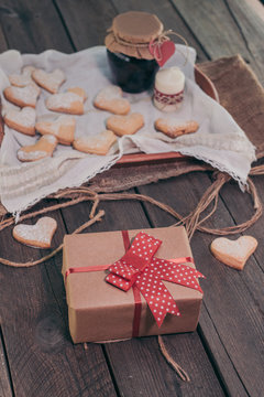 Heart shape cookies on wooden background with gift box