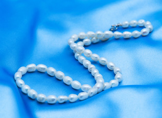 Pearls a necklace on a silk fabric