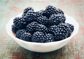 Blackberries in a bowl on wooden table