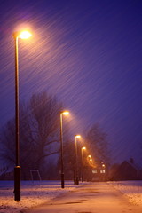 Row of lampposts in a snowy winter night