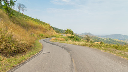 road to moutains with clouds in blue sky