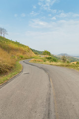 road to moutains with clouds in blue sky