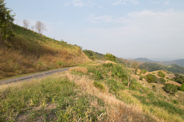 road to moutains with clouds in blue sky