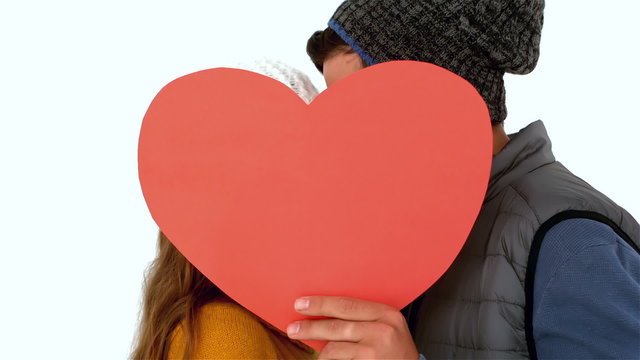 Couple hiding faces with heart shape