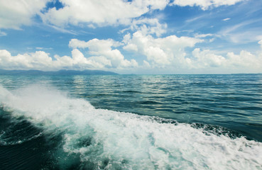 wave on sea and blue sky with clouds and sun
