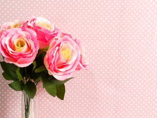 artificial rose flower close up on pink polka dot with space copy background