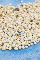 un-roasted coffee beans heap with shallow depth of field